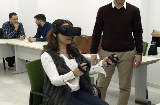 imagen de la practica en la que una mujer porta gafas de realidad virtual y mandos en las manos.